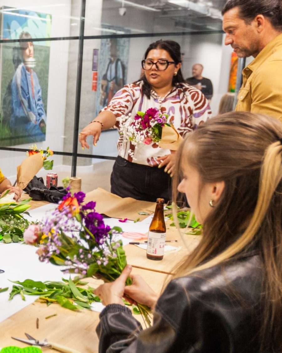 Farah leading a flower therapy workshop, holding up a bouquet of chrysanthemums and gypsophila
